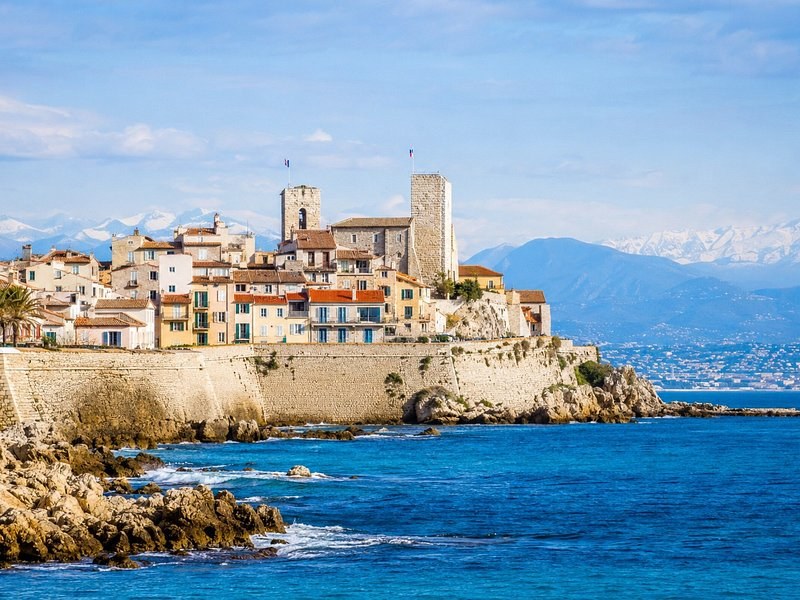 The ramparts and old town of Antibes on the sea, snow on the mountains behind