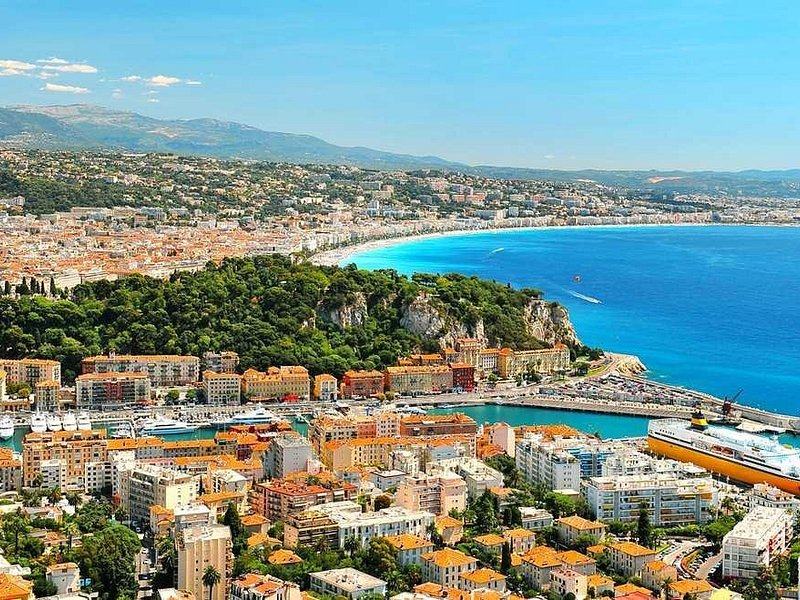 The harbour at Nice, the green hill beside it and the long bay beyond, from above